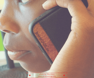 A person holding a cell phone up to their ear.