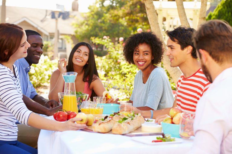 A group of people sitting at a table with food.