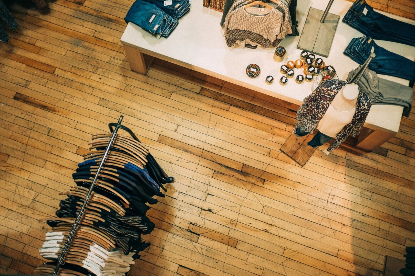 A person is shopping in a store with clothes on the rack.