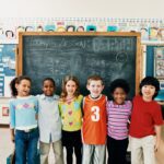 A group of children standing in front of a chalkboard.