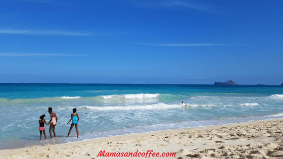 A woman walking on the beach near the ocean.