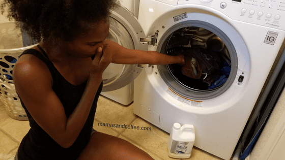 A woman is looking at the clothes in the dryer.
