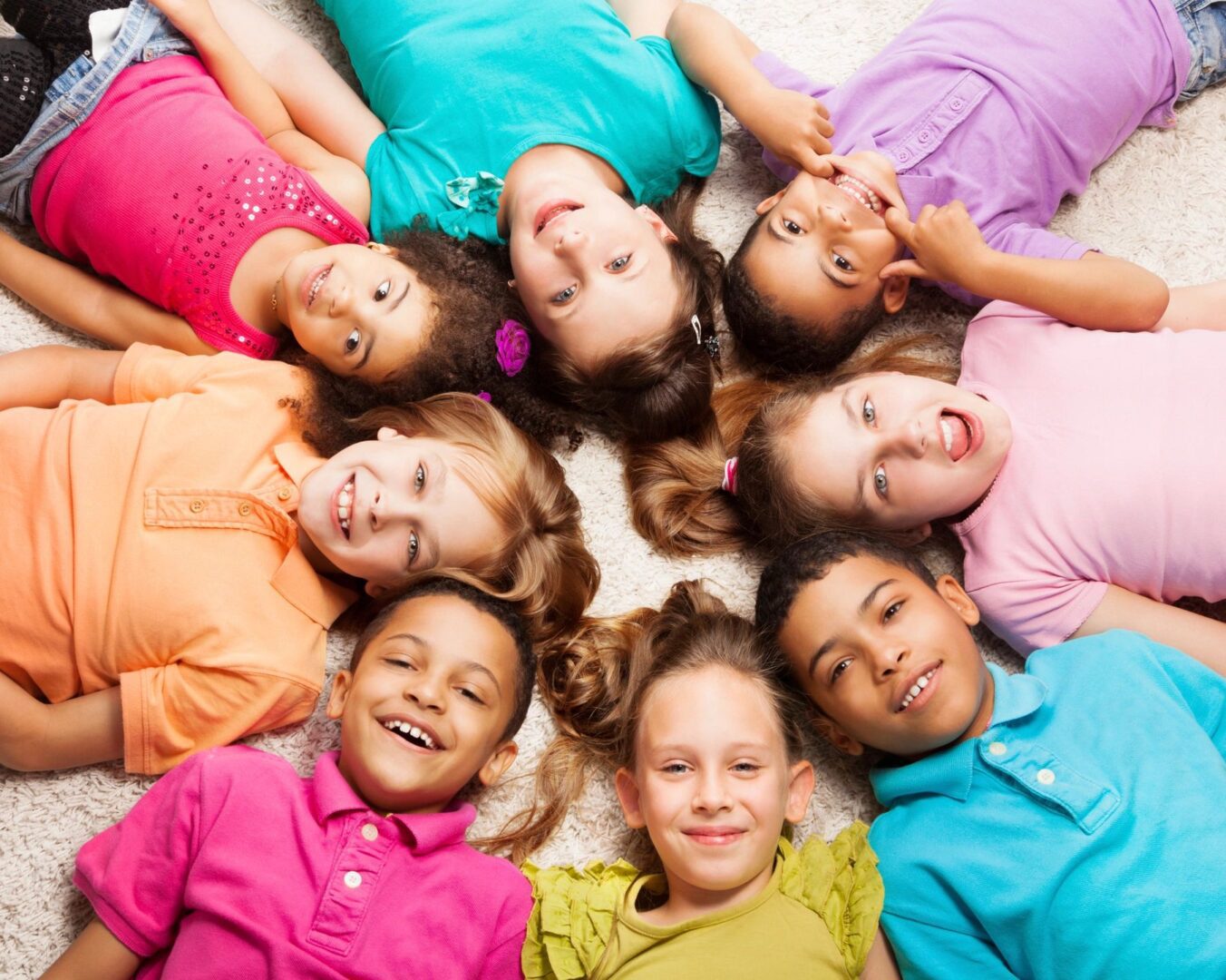 A group of children laying in the middle of a circle.