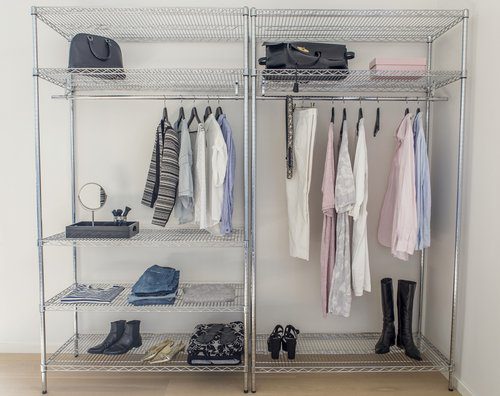 A closet with clothes hanging on the rails.