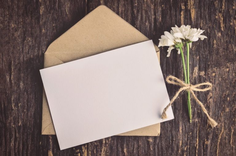 A white card sitting next to an envelope.