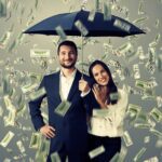 A man and woman under an umbrella with money falling from the sky.