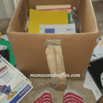 A box of books and papers on the floor