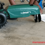 A person is using an orbit lawn mower.