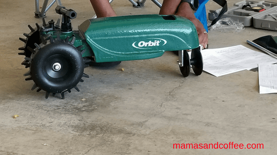 A person is using an orbit lawn mower.