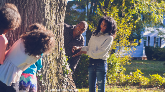 A man and woman standing next to a tree.