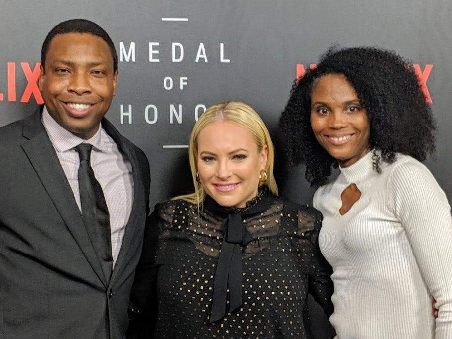 Three people posing for a picture at the medal of honor awards.
