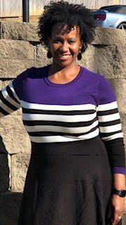 A woman in purple and white striped sweater.