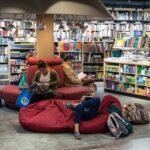 A group of people sitting on bean bag chairs in a library.
