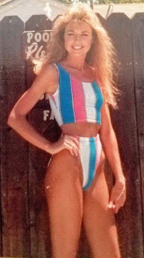 A woman in a striped bikini posing for the camera.