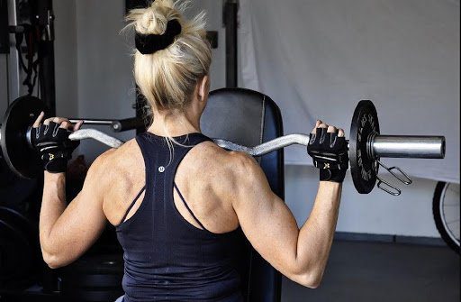 A woman is lifting some weight in the gym