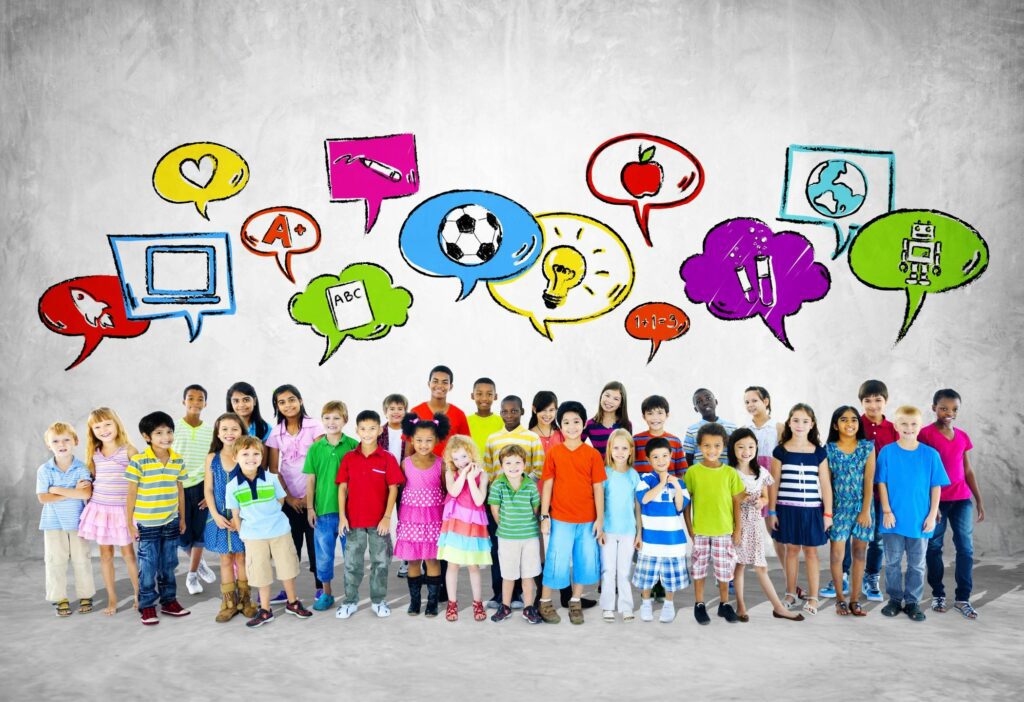 A group of children standing in front of a wall with speech bubbles.