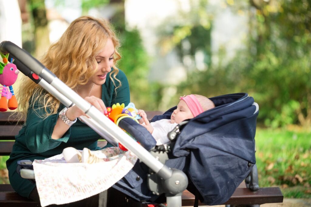 A woman feeding her baby in the park