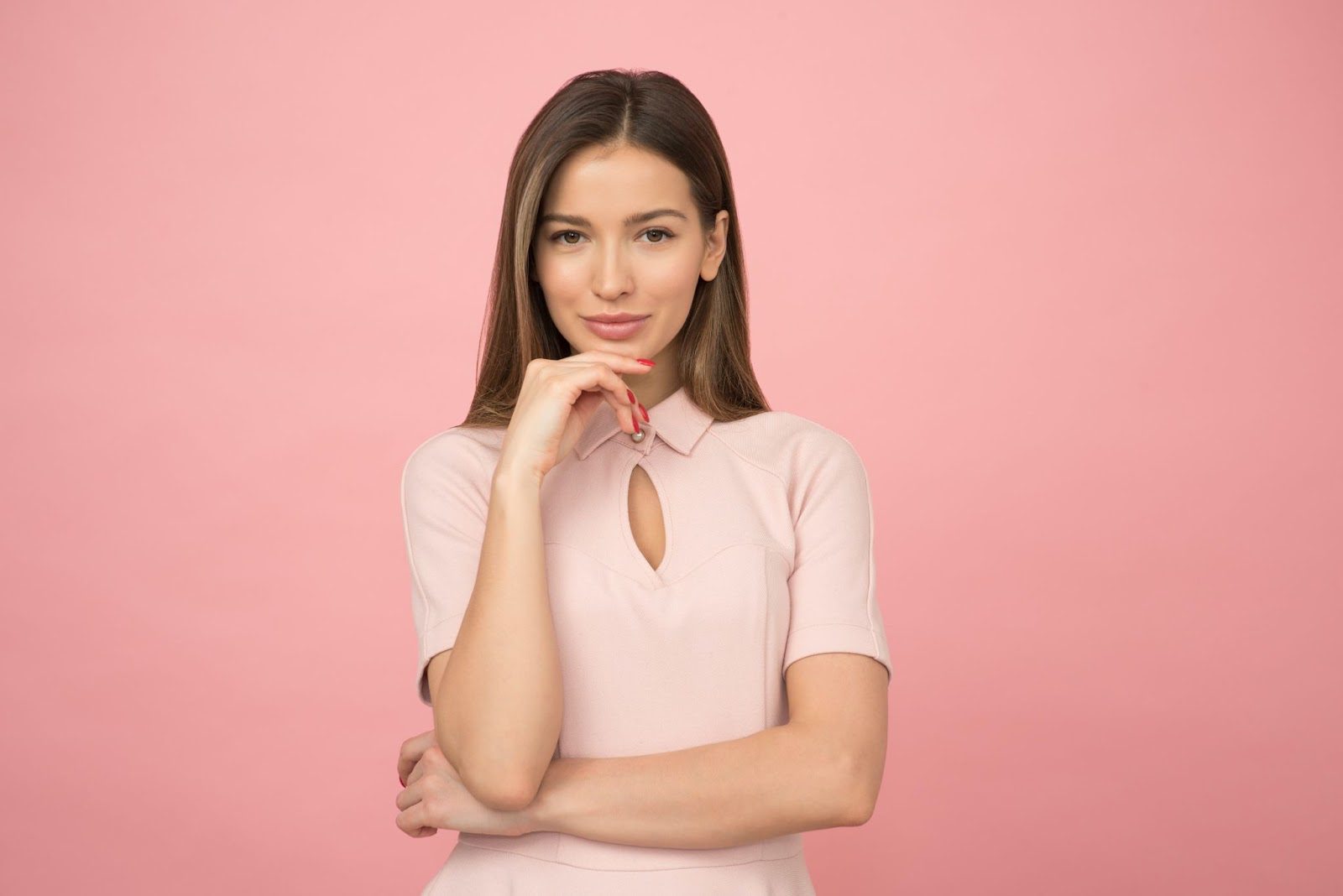 Create a young woman in a pink dress posing with her hand on her chin, while she embraces the journey to create a happy and fulfilling life for herself.
