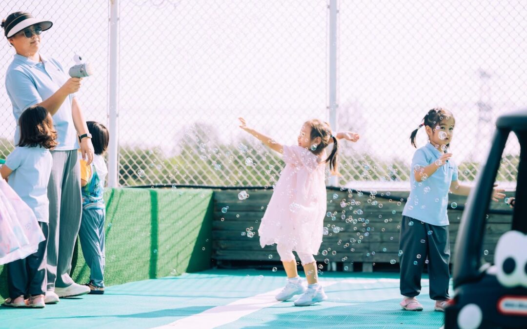 A group of children playing on a tennis court.